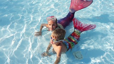 Children dresses as sirens in pool